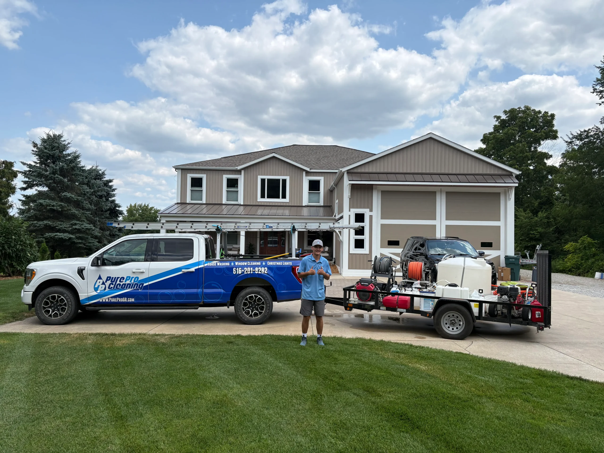 Power washing in West Michigan - technician beside a PurePro truck and pressure washing trailer at a home